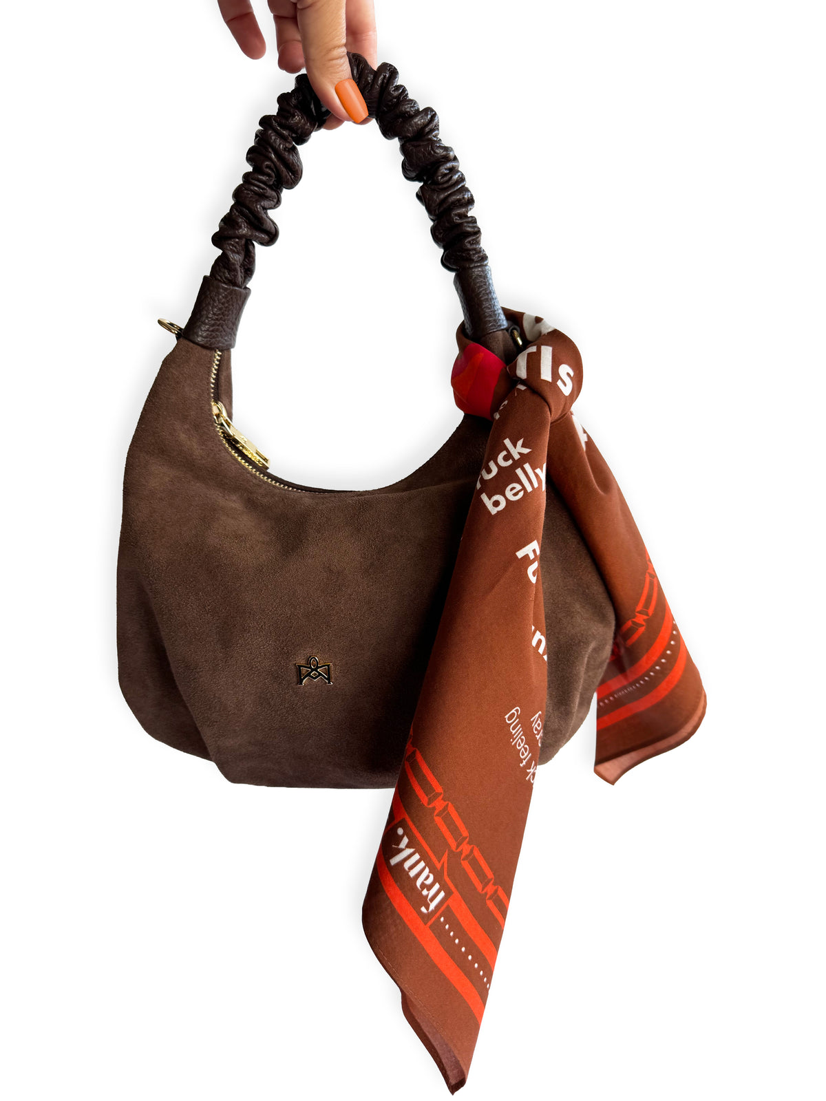 Brown and orange scarf tied around handle of brown suede handbag.