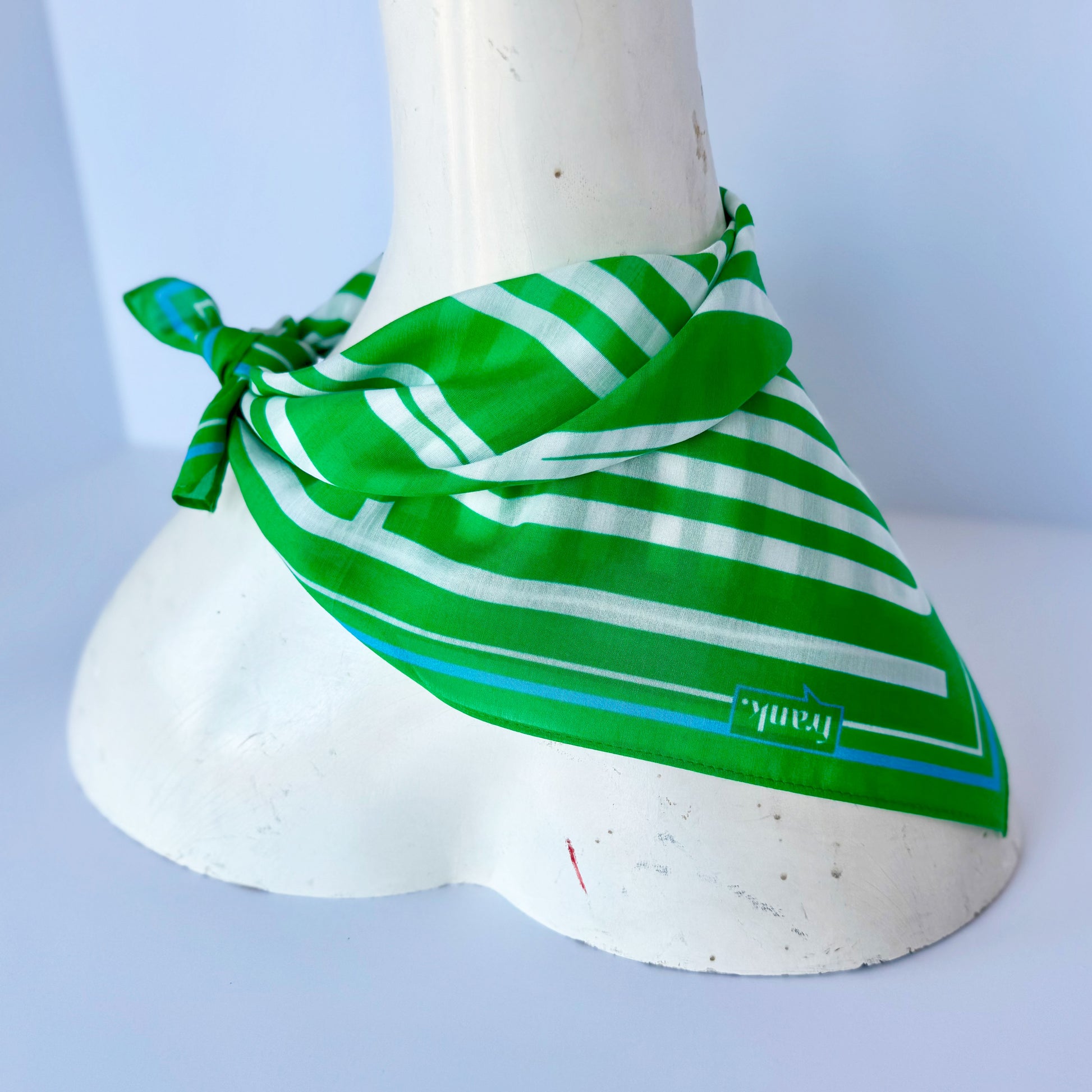 Green and white striped scarf / handkerchief on a mannequin on a white background