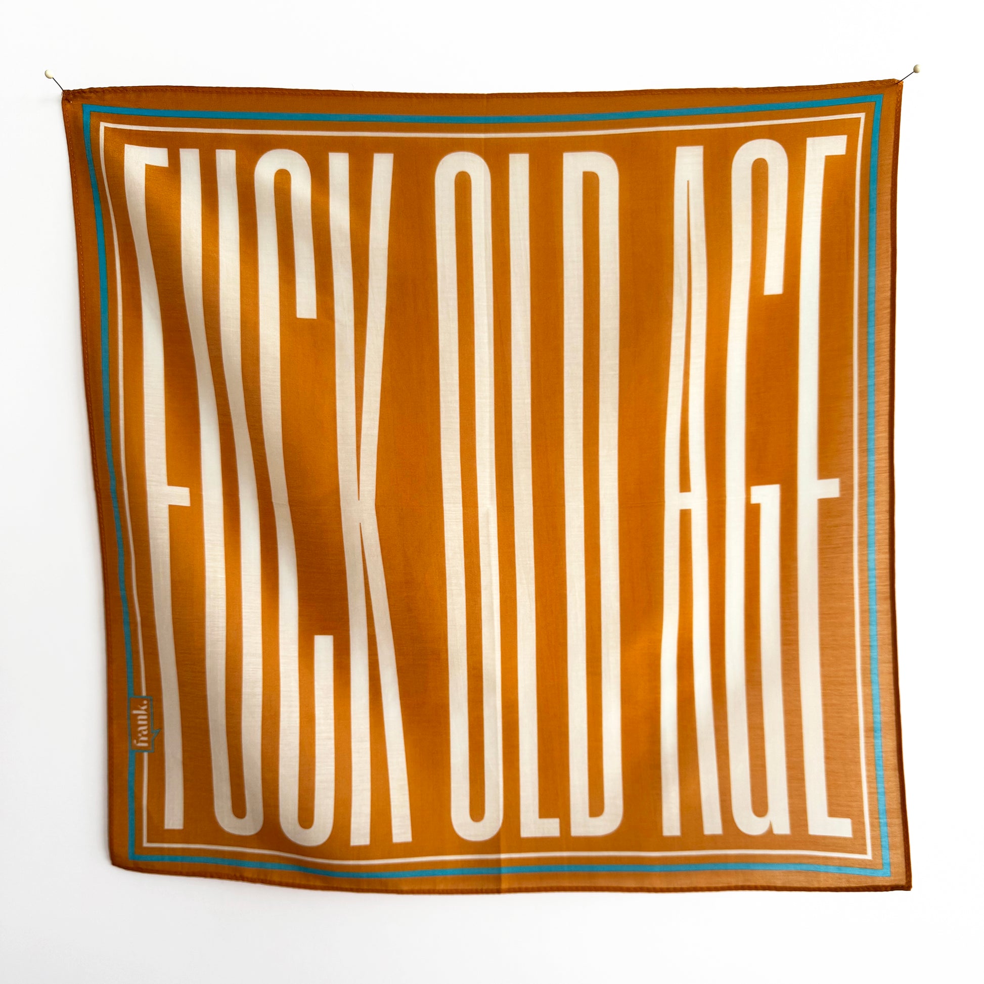 Gold silk blend scarf/handkerchief with a turquoise blue border. Elongated typography reads: Fuck Old Age.