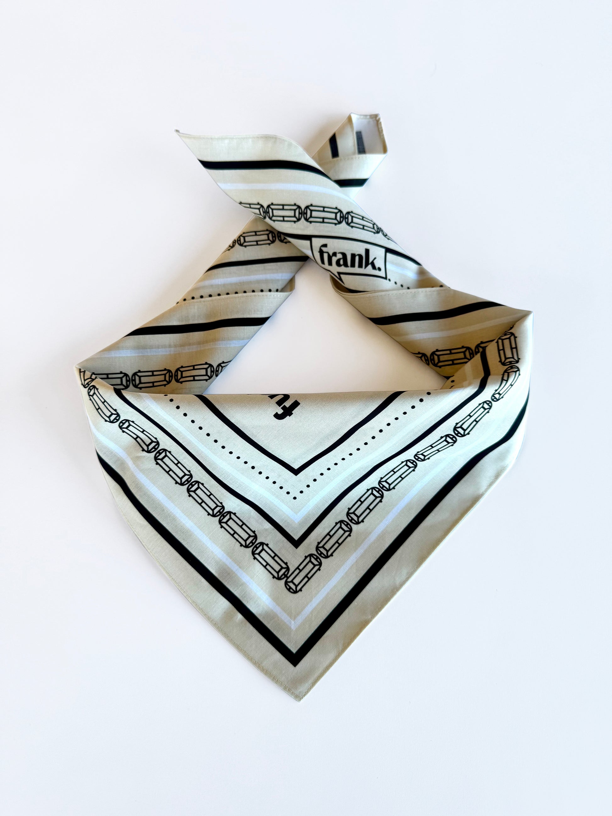 Beige cotton "Fuck It Bucket" bandana folded in a triangular pattern.