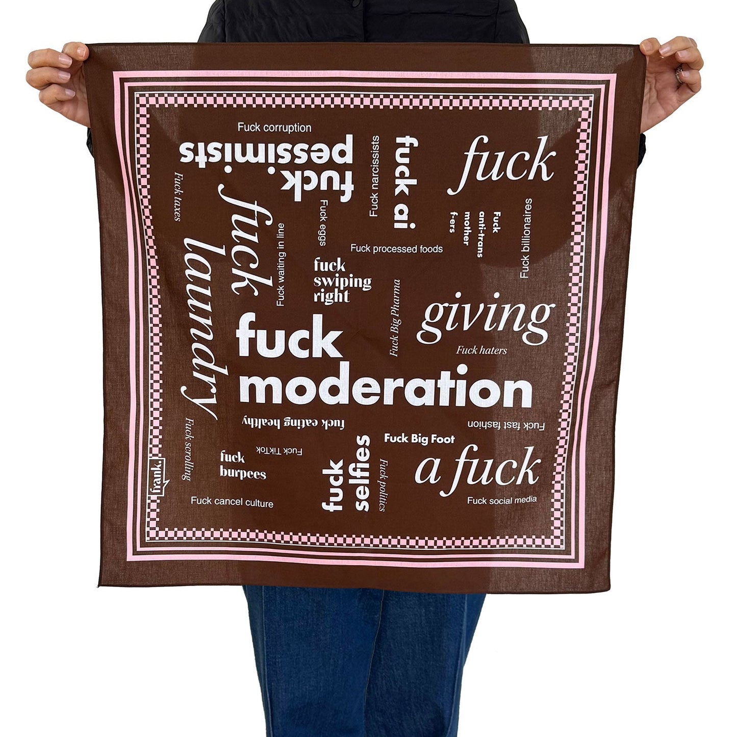 Person holding a brown bandana with themes including 'Fuck Moderation'.  Bandana has white text and a pale pink border.