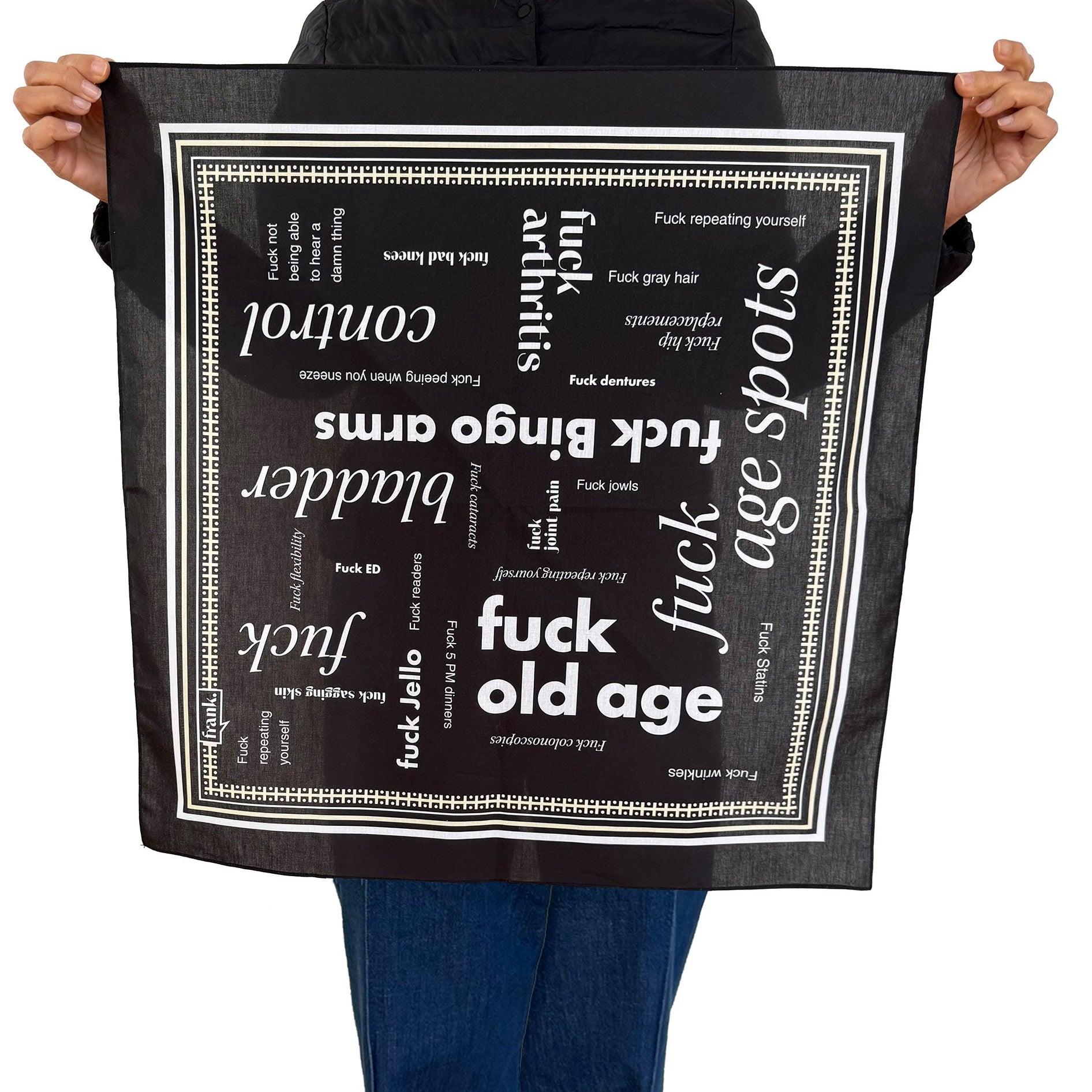 Person holding a black cotton 'Fuck Old Age' bandana with white text on a white background