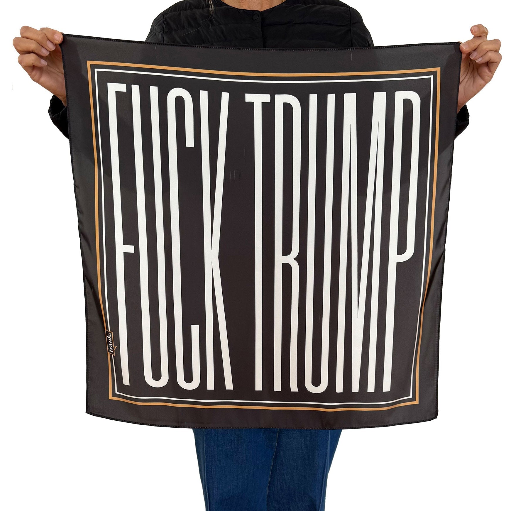Person holding a silky black scarf with 'FUCK TRUMP' printed in white.