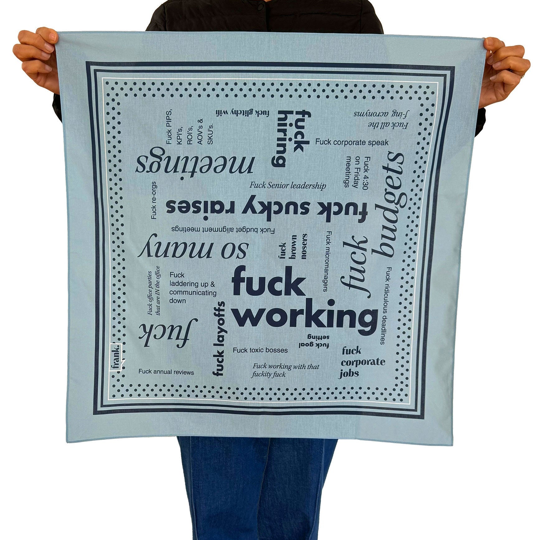 Person holding a large light blue cotton bandana with words around the theme of working including 'Fuck Working'.
