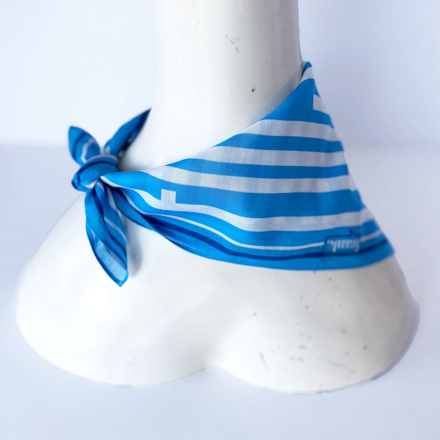 Blue and white striped handkerchief on a mannequin against a white background