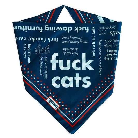 A navy blue bandana-style pet bandana featuring the words 'fuck cats' in large white text, surrounded by smaller white and red text, dots, and striped borders on a white background.