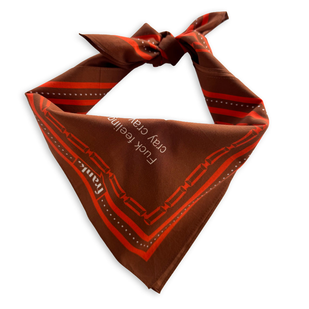 A brown bandana-style neck scarf with red and orange geometric border stripes and white text reading 'F*ck feeling cray cray, tied in a knot against a plain white background.